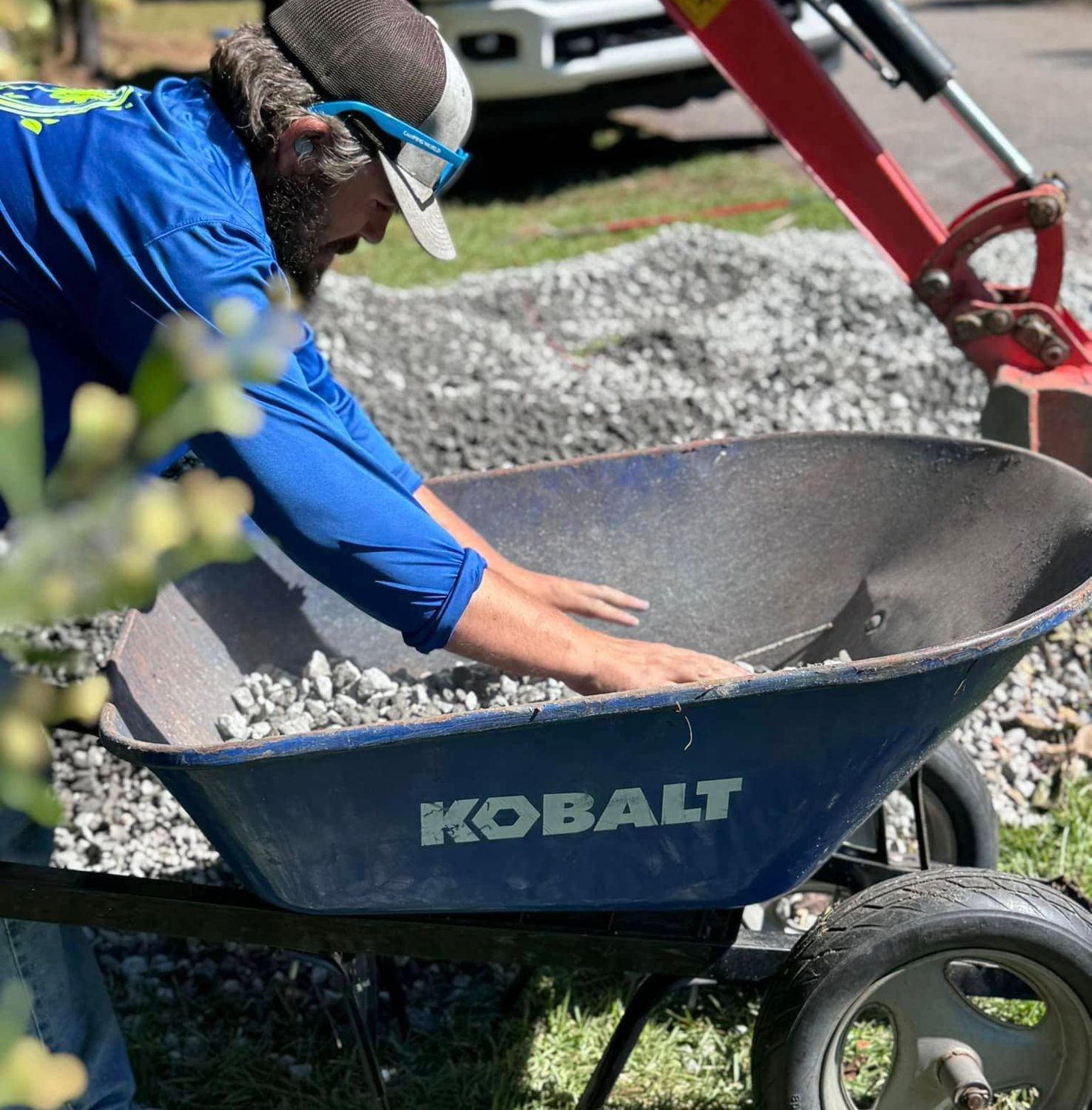 Landscaper loading decorative stone into wheelbarrow